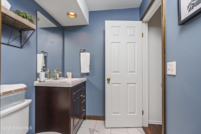 bathroom featuring recessed lighting, baseboards, toilet, and vanity