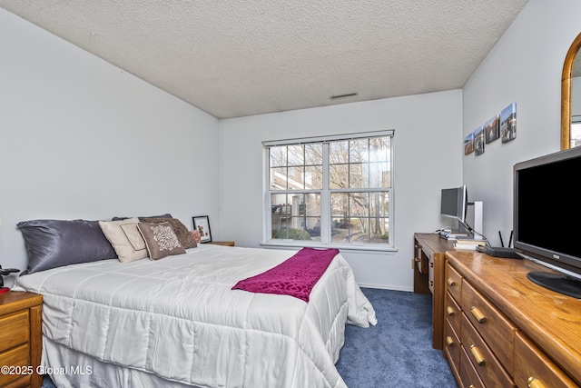 bedroom featuring visible vents, dark carpet, and a textured ceiling