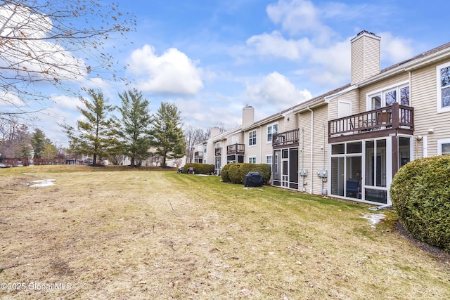 view of yard with a balcony and a sunroom