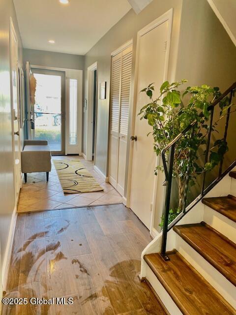 foyer entrance with stairs, recessed lighting, and baseboards