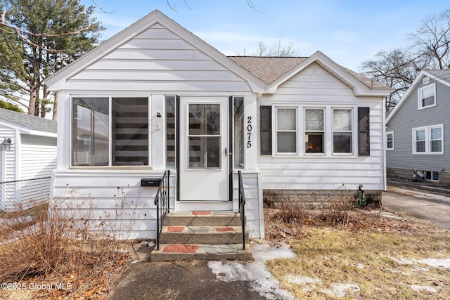 bungalow-style home with roof with shingles