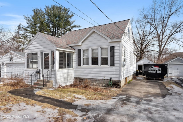 bungalow-style house featuring entry steps, an outbuilding, and roof with shingles