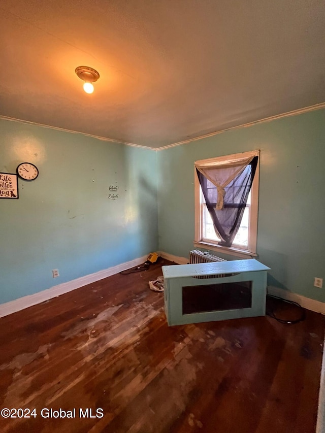 unfurnished room with baseboards, ornamental molding, and wood finished floors