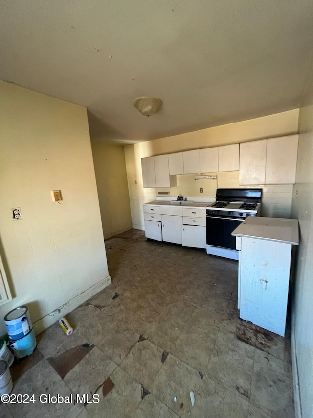 kitchen featuring white cabinetry, gas range, and light countertops
