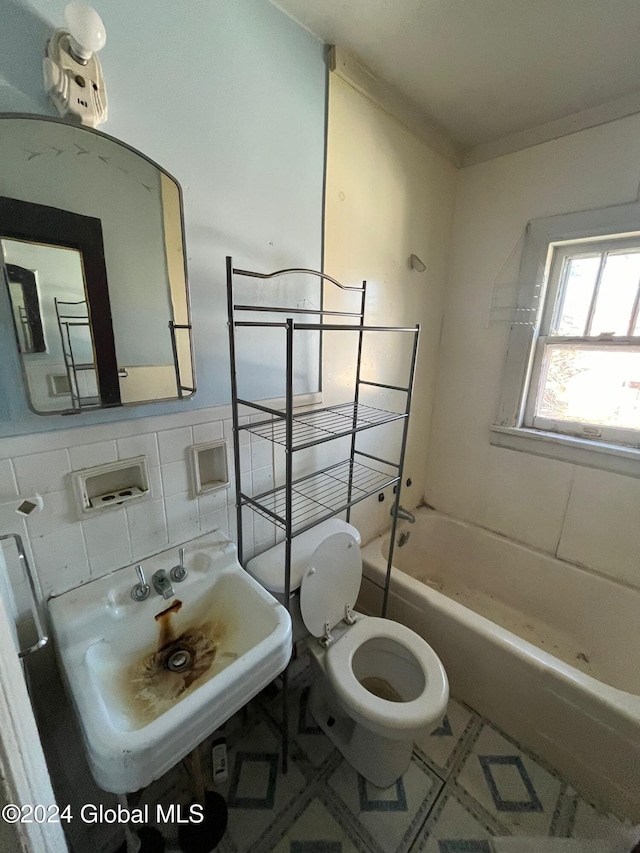 bathroom with toilet, a sink, decorative backsplash, ornamental molding, and tile walls