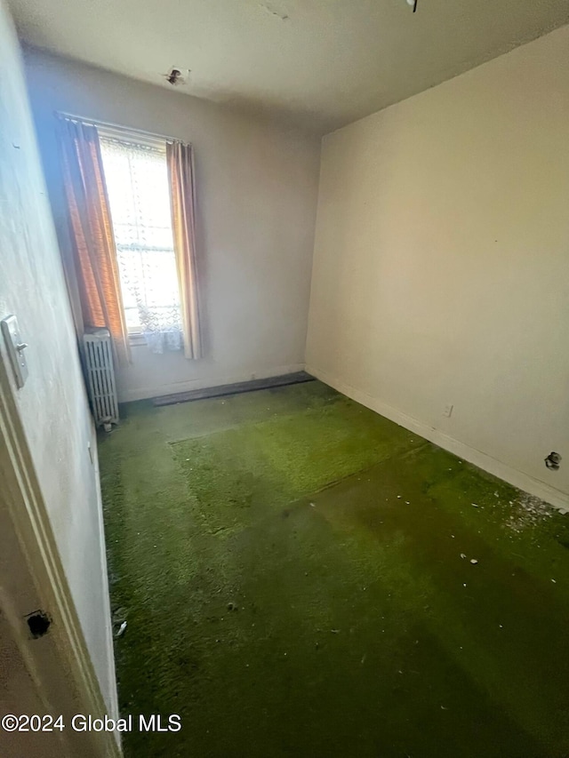 unfurnished room featuring radiator heating unit
