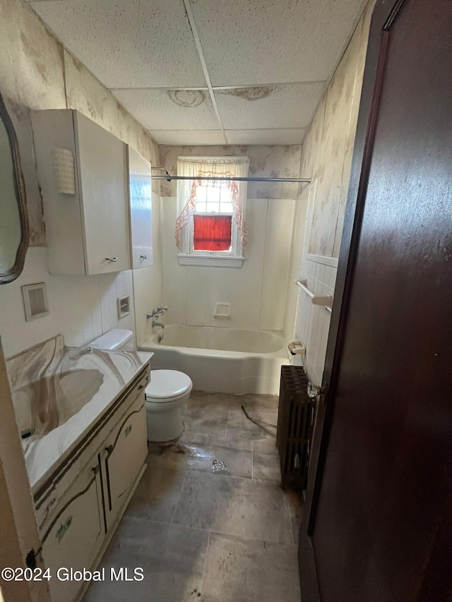 bathroom with vanity, radiator, toilet, bathtub / shower combination, and a drop ceiling