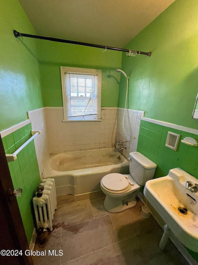 bathroom with radiator, toilet, tile walls, and shower / bathtub combination