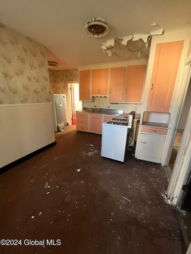 kitchen featuring a sink, visible vents, wallpapered walls, and white gas range oven