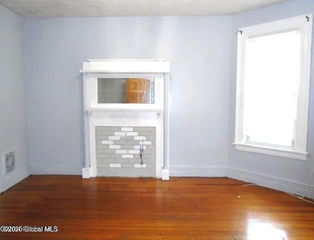 spare room with visible vents, baseboards, and wood finished floors