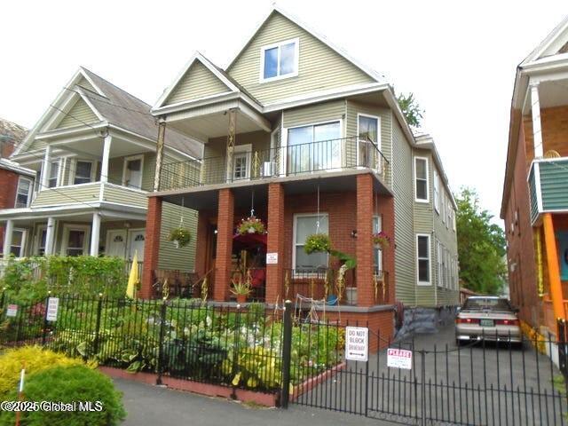 view of front facade with a fenced front yard and brick siding