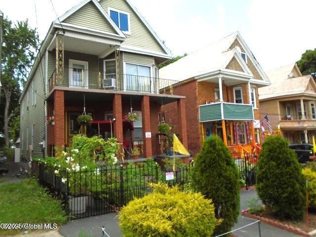 view of front of house with a balcony and fence