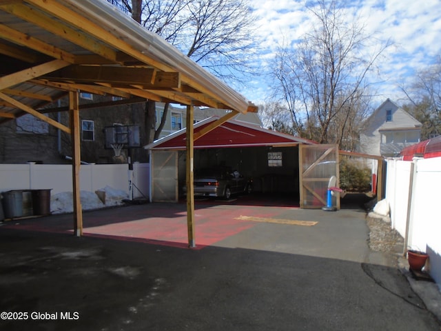 view of vehicle parking featuring a carport and fence