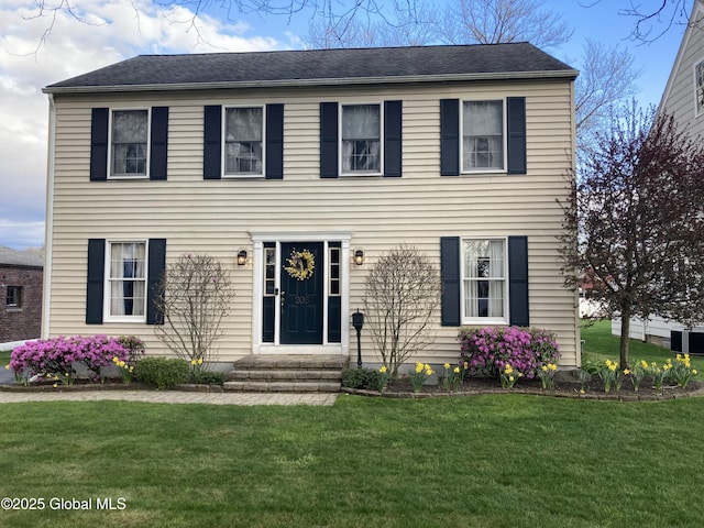 colonial inspired home featuring entry steps, a front lawn, and central air condition unit