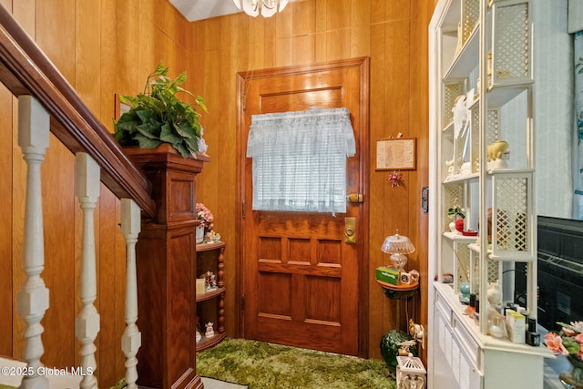 foyer entrance with stairway and wooden walls