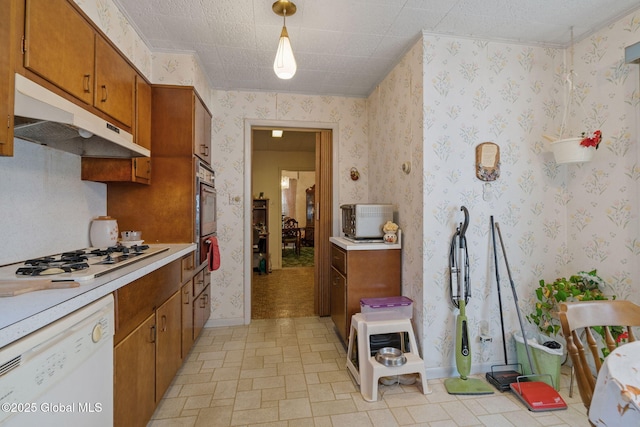 kitchen featuring under cabinet range hood, wallpapered walls, white appliances, brown cabinetry, and light countertops