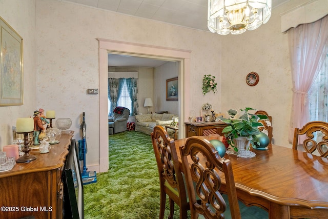 dining area with a notable chandelier, carpet flooring, and wallpapered walls