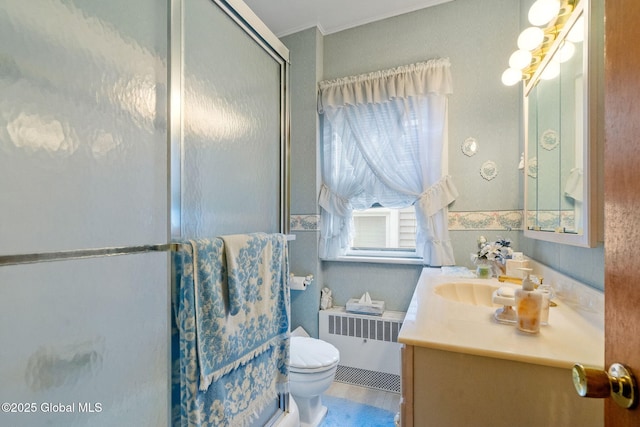 bathroom featuring vanity, radiator heating unit, a stall shower, ornamental molding, and toilet