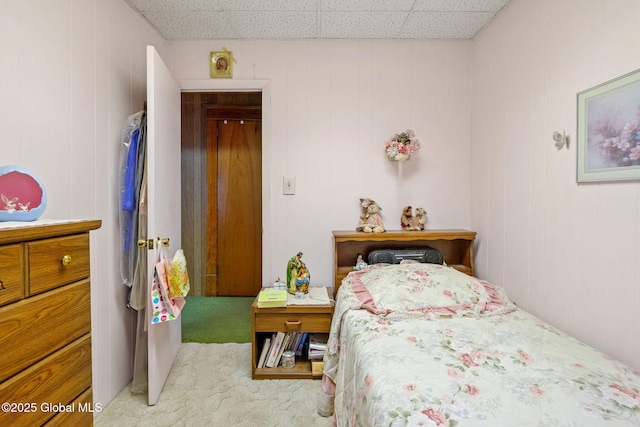 carpeted bedroom with a paneled ceiling