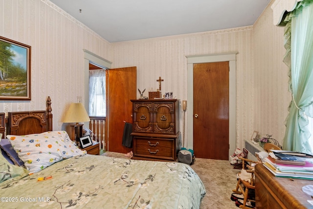 carpeted bedroom with wallpapered walls and radiator heating unit