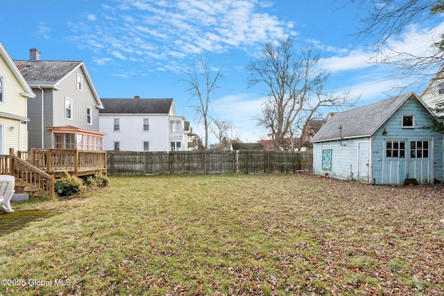 view of yard featuring an outbuilding, a fenced backyard, and a wooden deck