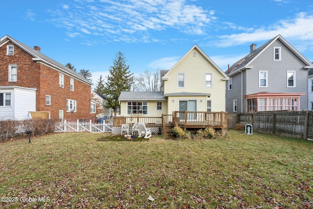 back of house featuring a wooden deck, a lawn, and a fenced backyard