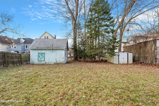 view of yard featuring an outdoor structure, a storage unit, and a fenced backyard