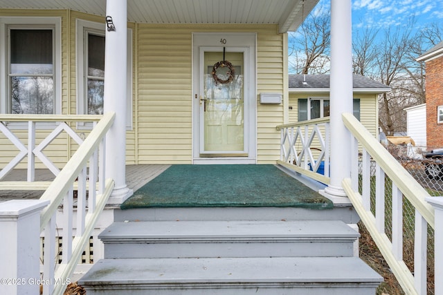 doorway to property with roof with shingles and covered porch