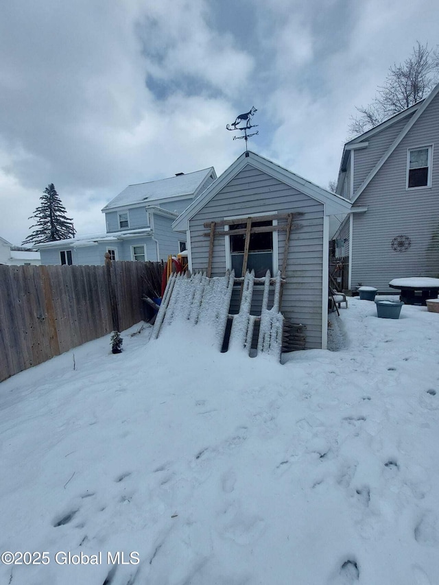 snow covered property featuring fence