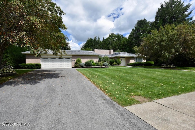 ranch-style home featuring brick siding, aphalt driveway, a garage, and a front yard