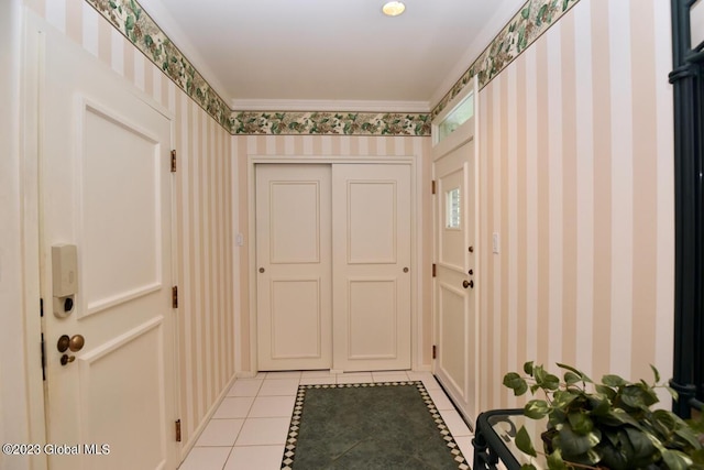 doorway with wallpapered walls and light tile patterned floors