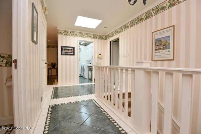 hall with wallpapered walls, a skylight, and tile patterned flooring