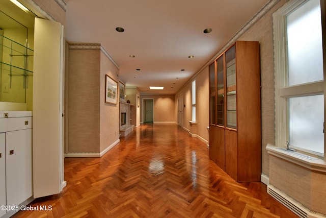 corridor featuring recessed lighting, a baseboard radiator, baseboards, and a healthy amount of sunlight