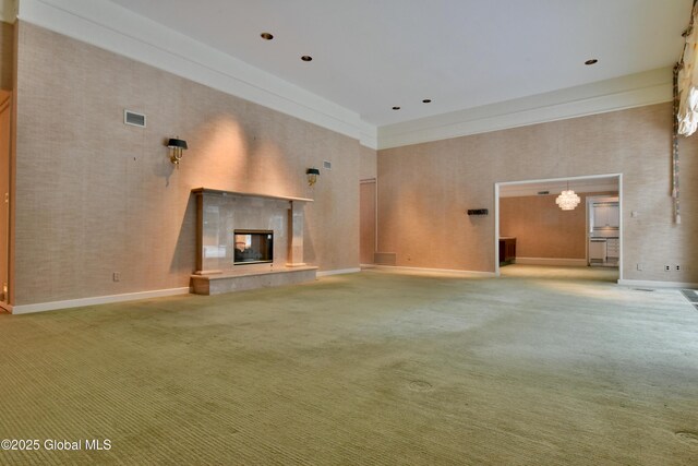 unfurnished living room with visible vents, a high ceiling, carpet flooring, and a tile fireplace