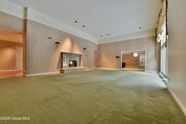 unfurnished living room featuring a multi sided fireplace, carpet, and a high ceiling