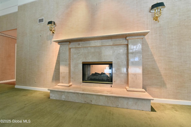 details featuring baseboards, carpet, visible vents, and a premium fireplace