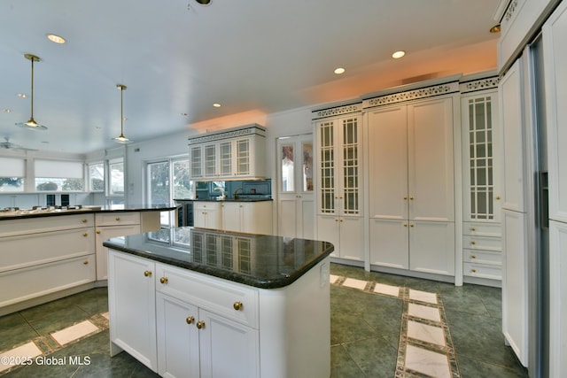 kitchen with a center island, glass insert cabinets, recessed lighting, hanging light fixtures, and white cabinetry