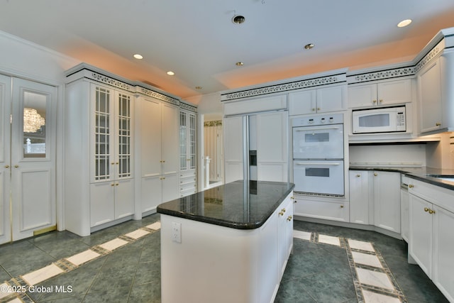 kitchen featuring dark tile patterned floors, recessed lighting, white appliances, and a kitchen island