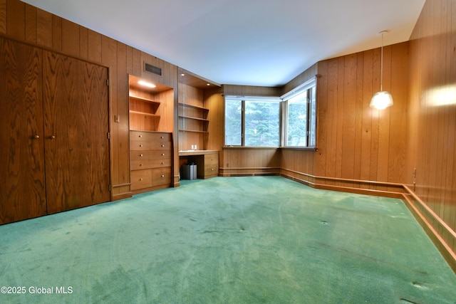 interior space featuring wooden walls, visible vents, and carpet