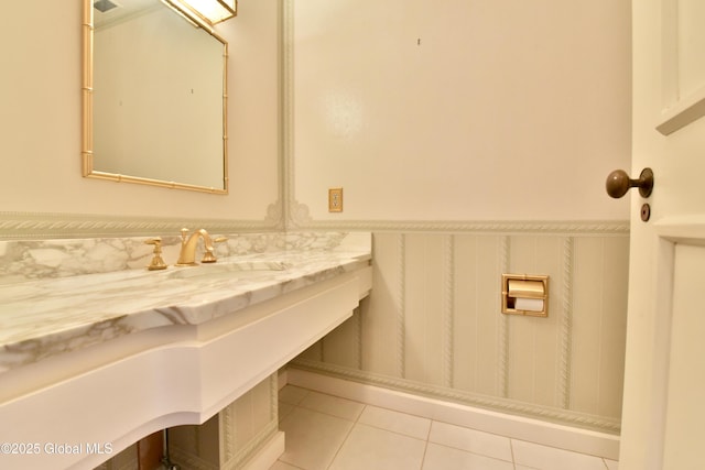 bathroom featuring a sink, a wainscoted wall, and tile patterned flooring