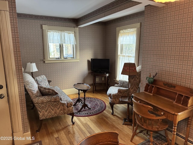 sitting room with wallpapered walls, light wood finished floors, and baseboard heating