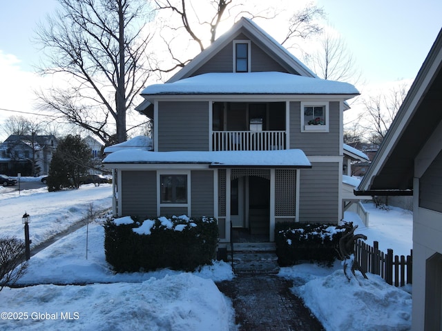 view of front of house with a balcony and fence