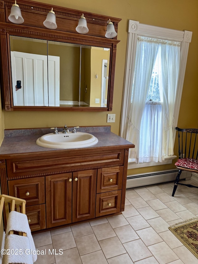 bathroom featuring tile patterned floors, a baseboard heating unit, and vanity