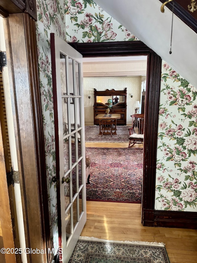 interior space featuring french doors, wood-type flooring, and wallpapered walls