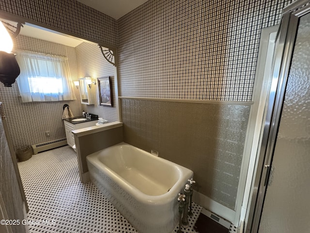 full bathroom with vanity, a garden tub, tile patterned floors, tile walls, and a baseboard radiator