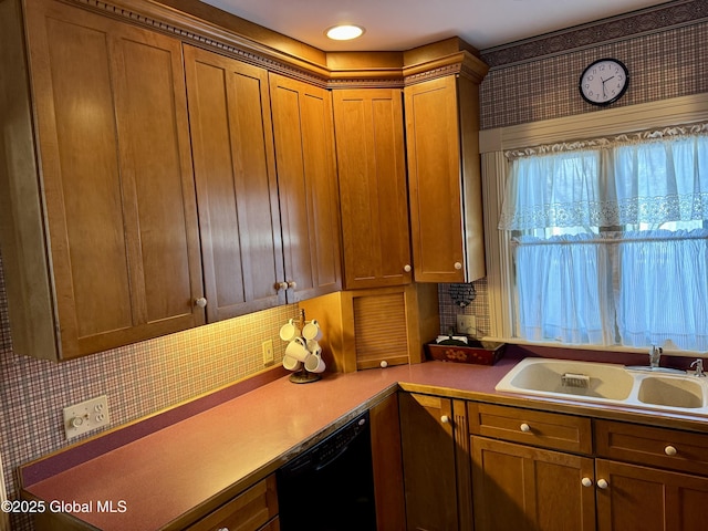 kitchen featuring brown cabinets, a sink, backsplash, black dishwasher, and light countertops