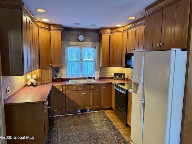 kitchen with brown cabinetry, a sink, black electric range, white fridge with ice dispenser, and light wood-type flooring