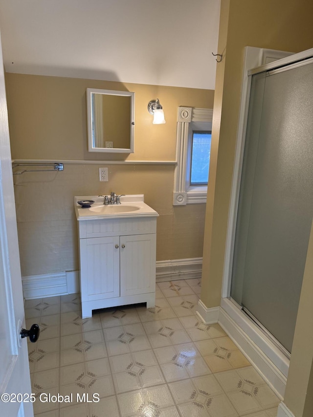 full bathroom featuring a stall shower, vanity, and tile walls