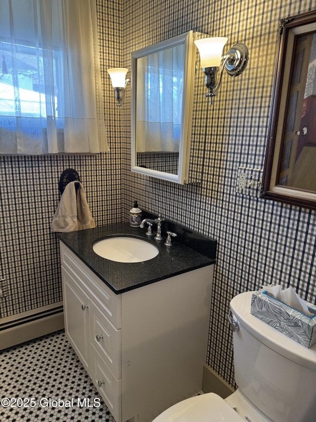 bathroom with wallpapered walls, toilet, tile walls, and vanity