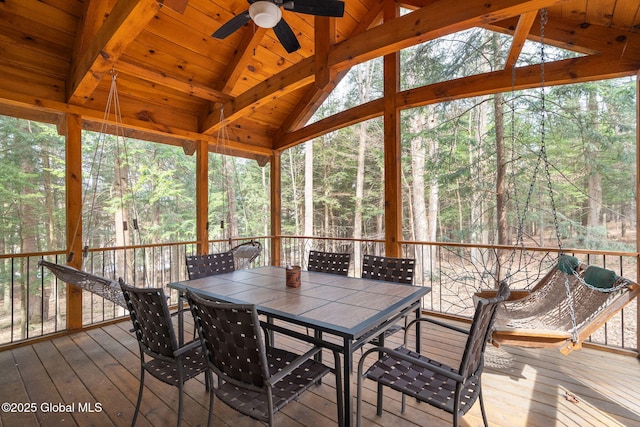 sunroom / solarium with wood ceiling, lofted ceiling with beams, and a ceiling fan